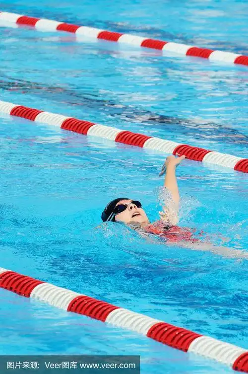 小女孩运动员在游泳池中进行仰泳比赛