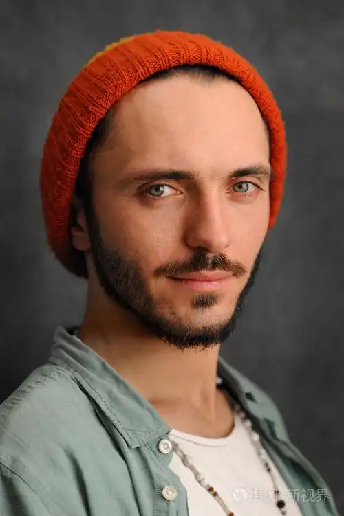 严重的年轻人留着胡子,戴红色帽子的小胡子