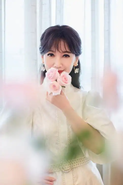 赵雅芝白色泡泡袖短裙秀美腿 持粉色玫瑰人比花娇