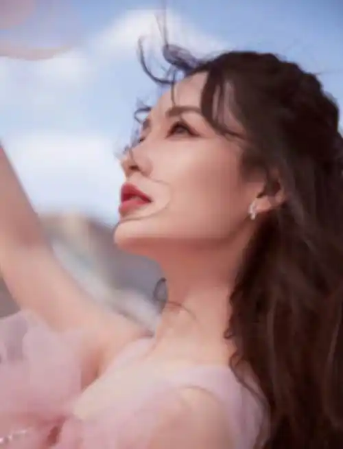 李沁一袭轻盈飘逸的粉红纱裙,温柔卷发,精致美妆