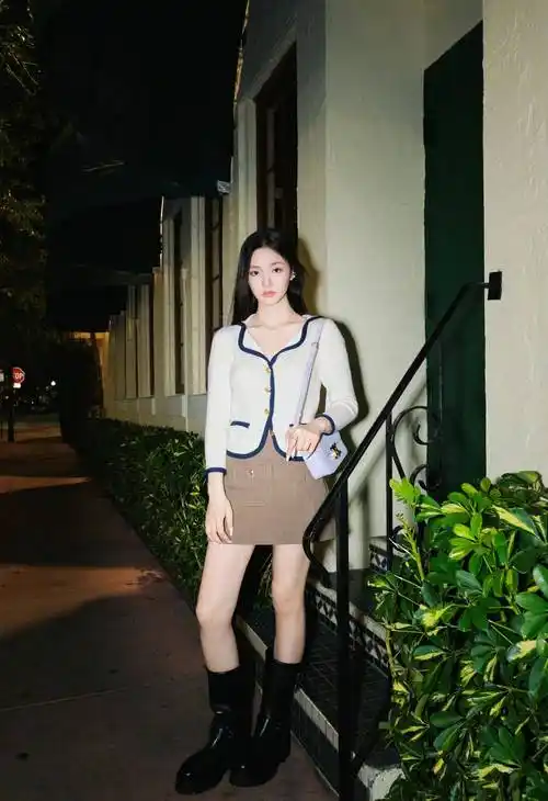漫步在夜色中,林允的白色毛衣和棕色超短裙秀出了她的美腿,时尚女神范