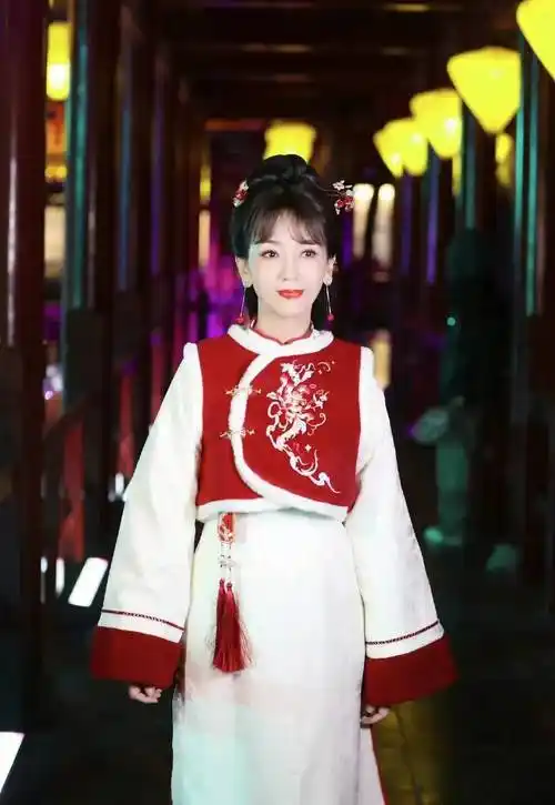 照片中的赵雅芝,身着红色中国风马甲和白色旗袍,不仅展现了浓厚的
