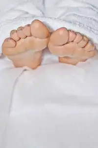 停尸房里的概念白人赤脚,裹着一条白毛巾,躺在沙发上,从毯子下面往外