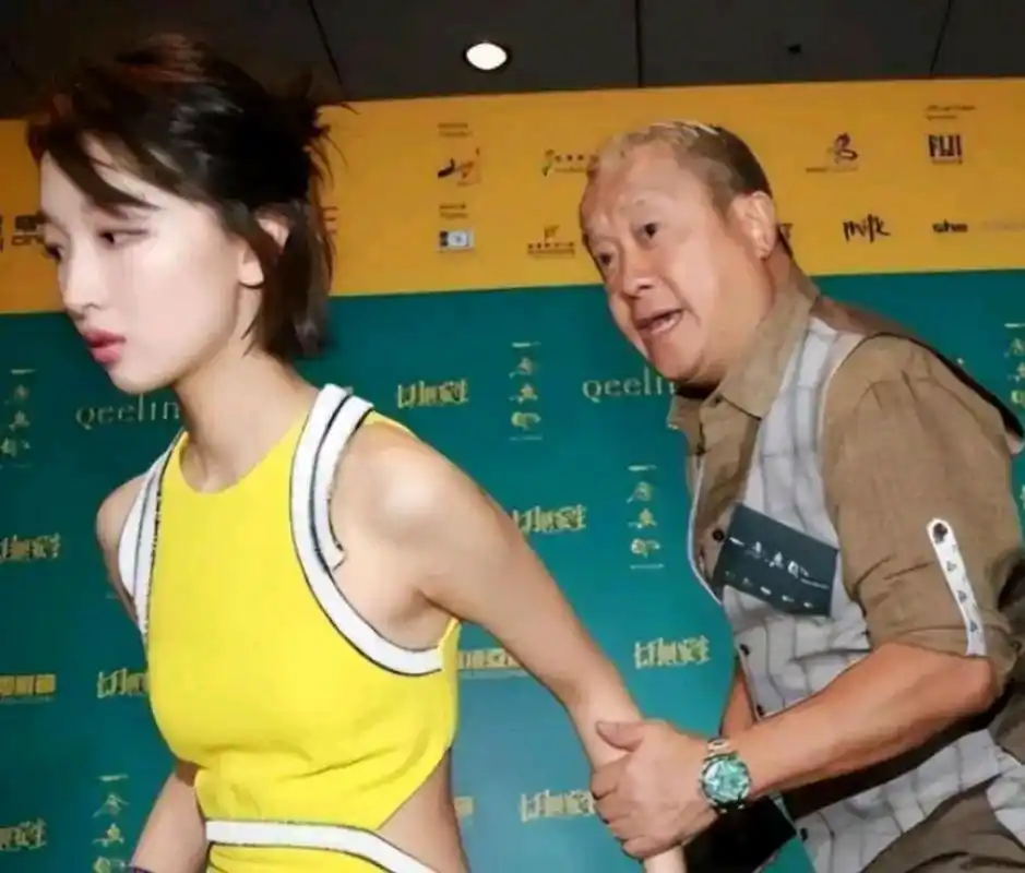 这张照片拍摄于2021年,曾志伟拉着周冬雨的手,周冬雨一脸嫌弃,着急麻