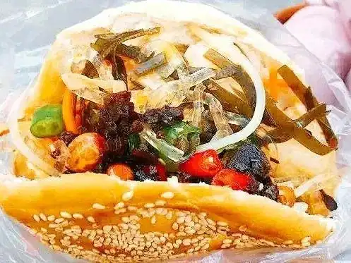 图/杭州我最懂 烧饼夹上鸡蛋,网状花干 再夹上土豆丝,海带丝,辣椒