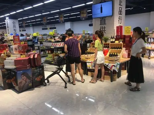 图为盛瑞商贸促销员向顾客现场介绍活动葡萄酒.