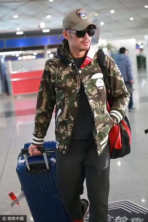 林丹黑超遮面一身迷彩外套运动风 肩上手上被行李"承包"行色匆匆
