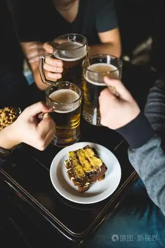 封闭的男性手碰杯啤酒在酒吧或酒馆