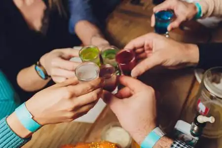 一组人在博克背景前用葡萄酒或香槟碰杯的特写镜头.老年人的手照片