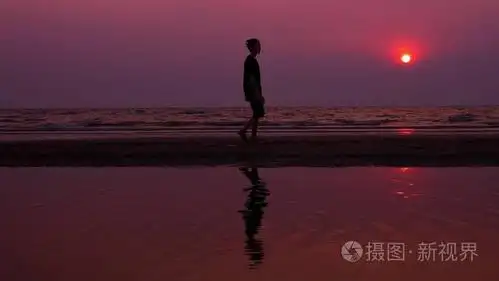 孤独的亚洲年轻人在日落时平静地沿着荒芜的海滩散步.海景