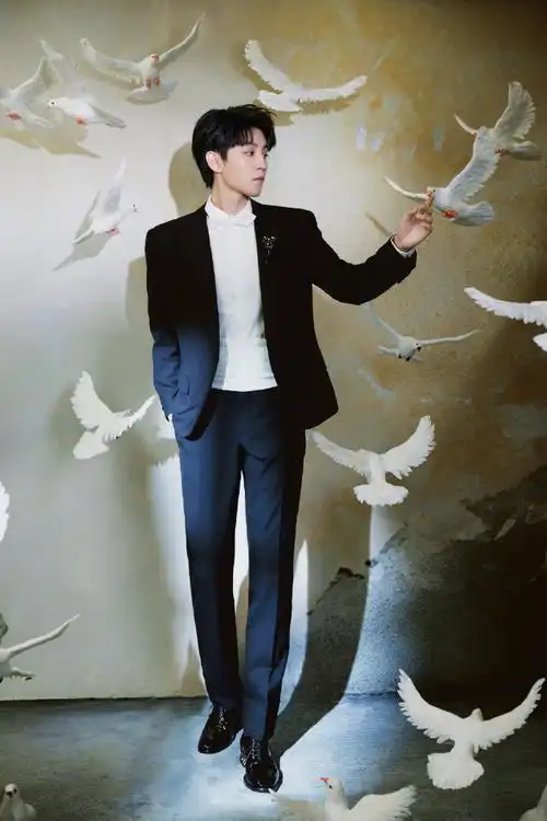 王俊凯身穿黑白西装,手持黄玫瑰与白鸽拍摄大片,贵气十足,妥妥小王子