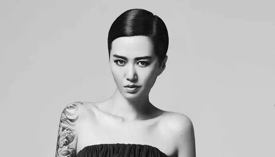 中国纹身明星谭维维手臂上黑灰色的浪花纹身图片