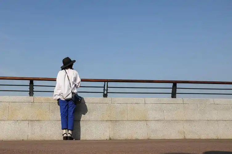 一个在江边观赏城市风景的女人站姿背影