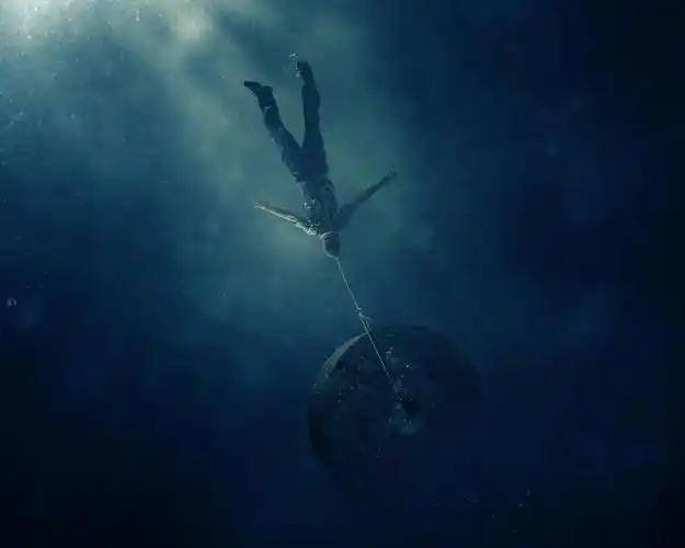 一个人脖子上挂着石头沉入海底