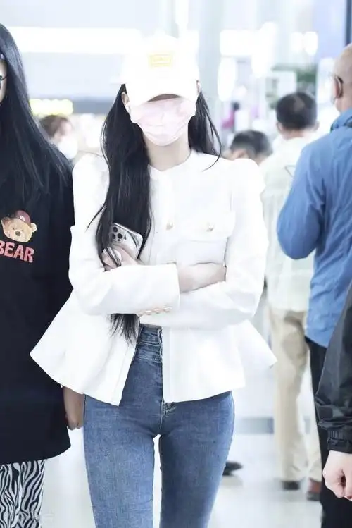 歌手孔雪儿头戴鸭舌帽身着白色外套配牛仔裤运动鞋休闲随性