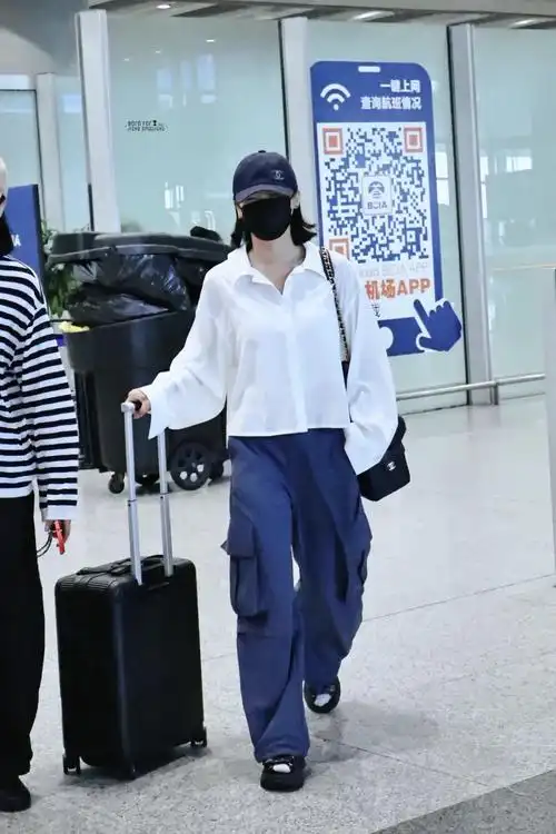 辛芷蕾机场街拍,白衬衫配工装裤率性洒脱!