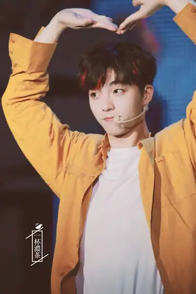 是蔡徐坤了,穿着拼接的各自衬衫,蓝色的破洞裤,先是歪着头给大家比心