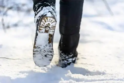 冬季雪地行走中的女性脚靴