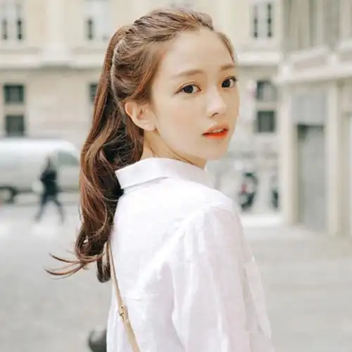 这是款棕色卷发马尾辫发型采用无刘海的扎