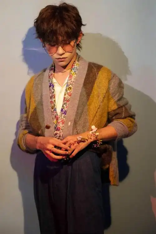 易烊千玺立麦的姿势太帅气了!粉框眼镜搭配手部花环营造唯美画面