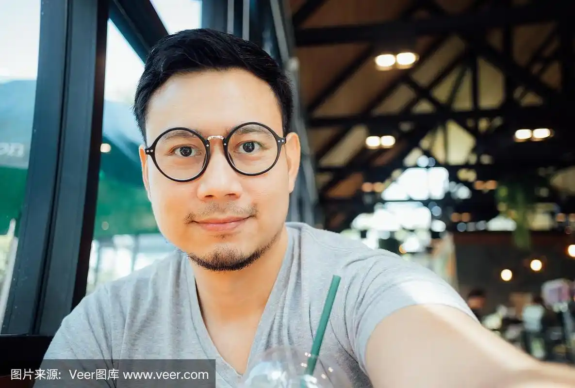戴眼镜的男人在咖啡馆喝咖啡自拍.