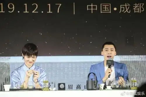 李宇春李易峰同台活动,李宇春长裙女人味十足,小动作还有点害羞