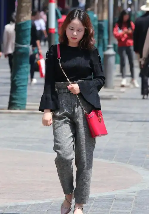 美女手搭凉棚在强烈的阳光下行走,给人一种很懒散的感觉