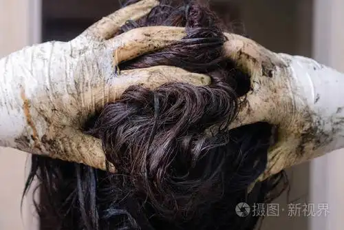 一个女人戴着橡胶手套,一个人在浴室里把头发扎死