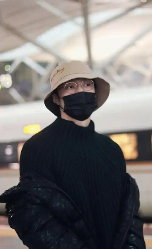 张艺兴行程饭拍图,身着深色毛衣配亮闪羽绒服,休闲舒适男友穿搭