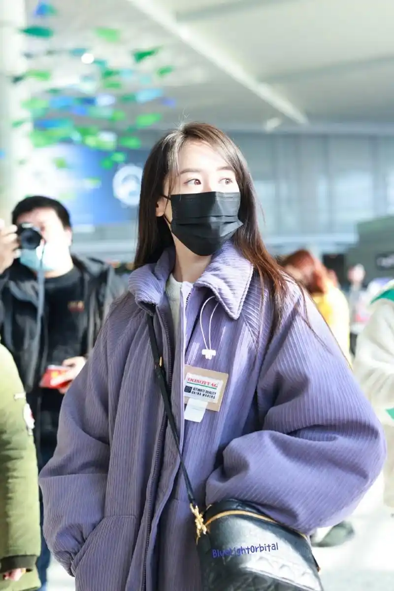 春运最in街拍#  袁冰妍机场街拍,身穿紫色宽松夹克内搭白色毛衣,搭配