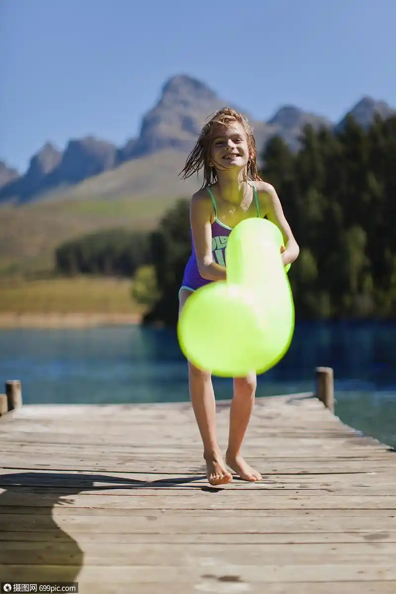 在码头上玩游泳池玩具的女孩