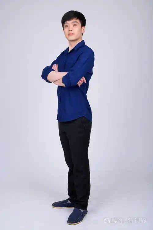 年轻的亚洲商人双臂交叉站着的全身镜头照片-正版商用图片15omhp-摄图