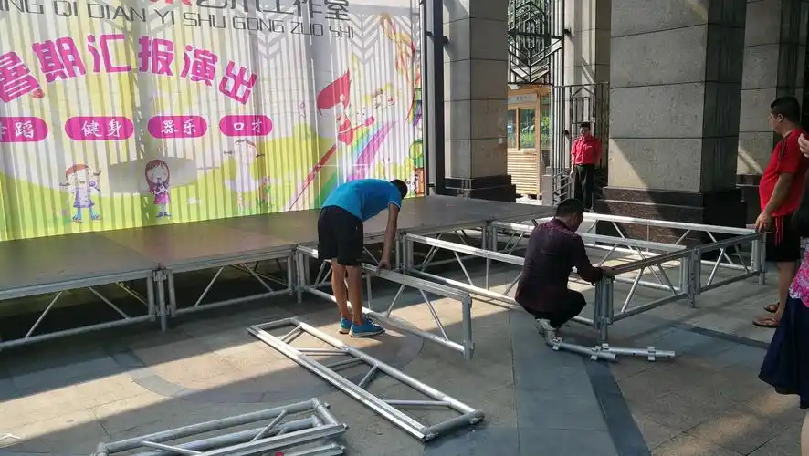 工作人员顶着高温紧张地为晚上的演出搭建舞台.