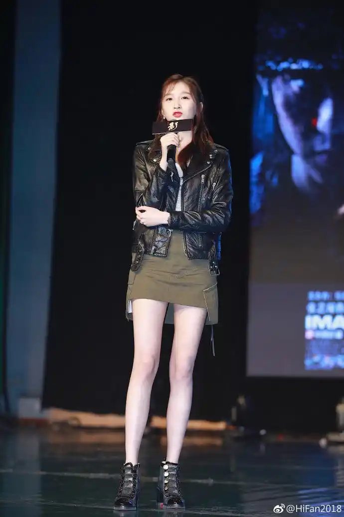 关晓彤穿黑色皮衣搭配绿色短裙现身宣传电影,拿话筒发言面带微笑