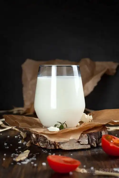 一杯带有牛奶,香料,樱桃西红柿和黄油的黑木桌照片-正版商用图片02r