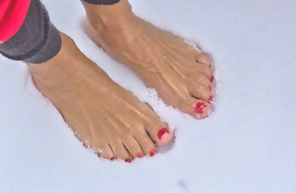 赤脚的女人,女人光着脚站在新鲜的雪