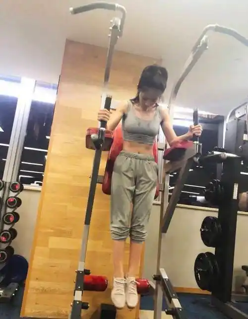 照片中,邢菲把头发高高梳起,运动服下腹肌隐约可见,无论是举哑铃还是