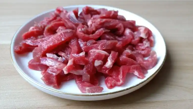黑胡椒牛柳,切好的牛肉丝放入盘里.