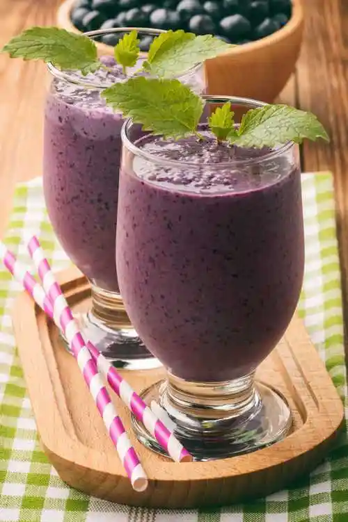 棕色木制背景上的蓝莓牛奶奶昔