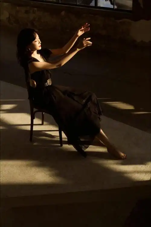 一袭黑色纱裙配卷发红唇,光影映衬优雅迷人气质,成熟女演员的魅力格调