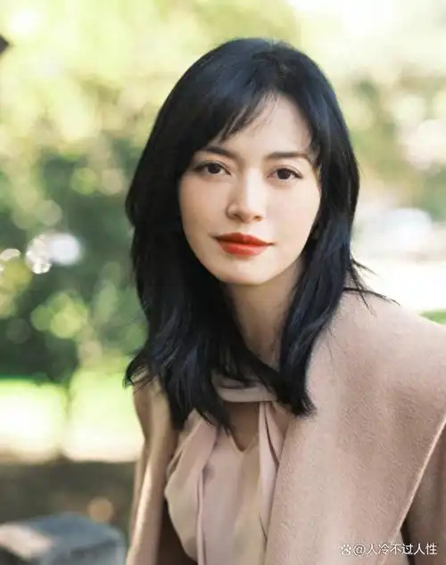 照片中,姚晨身穿黑色衣服,站在两座高楼之间.