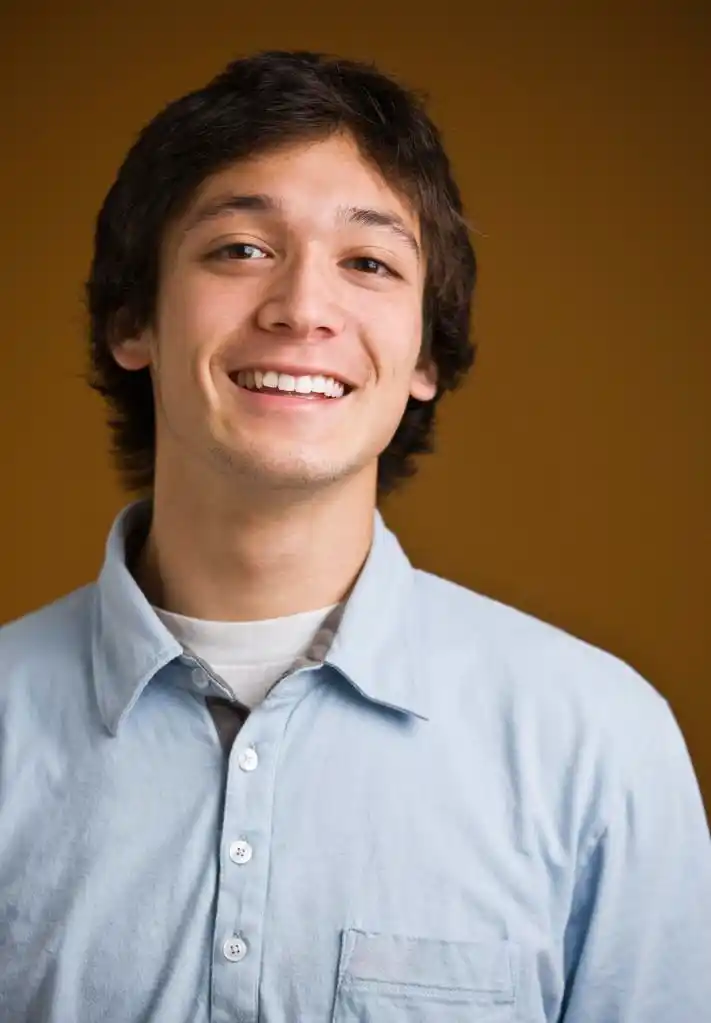 微笑的黑发男,魅力黑发年轻男性面对镜头,穿件衬衫下的按钮.垂直