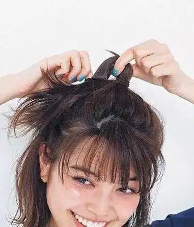 至发尾用黑色小发夹固定好,并用手稍稍拉扯一下头顶头发,打造饱满与