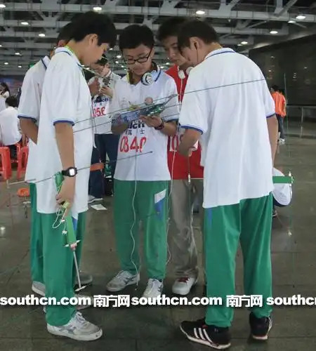 (来自广州市47中的学生正在讨论比赛 摄影:蔡明奕)