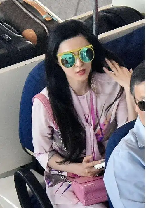 范冰冰又高调出行穿粉色套装拉lv拉杆箱走机场蓝色墨镜太吸睛
