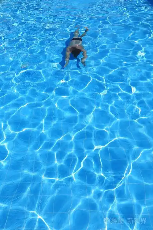 孤立的蔚蓝水池和游泳者在水中