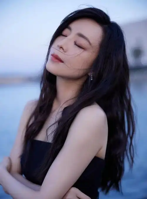 张静初媚骨天成挺柔的,穿抹胸黑裙秀腰身线条,看气度不像中年人