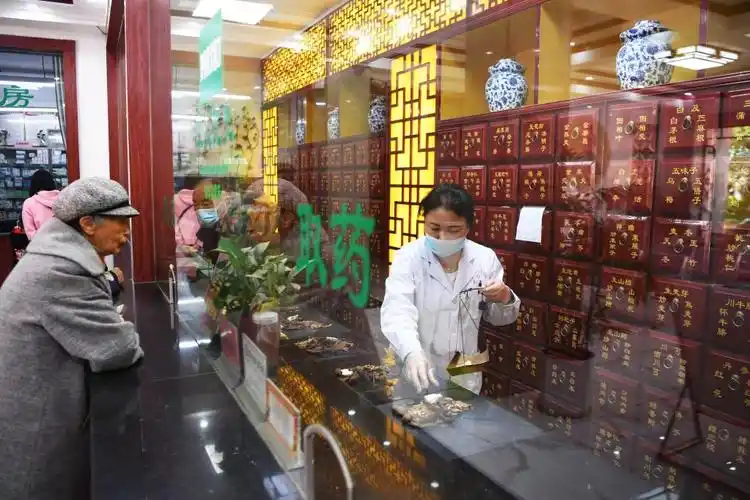 5月7日,南阳市卧龙区七里园乡卫生院中药房工作人员在为患者抓药.