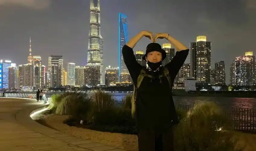 和雕塑鸟合影;时而把双手举到头顶,呆萌比心