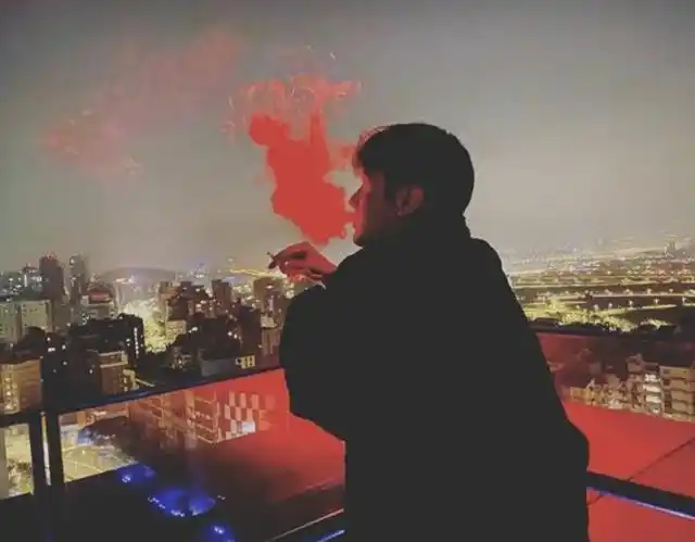 背影忧郁侧脸帅气逼人,手里的烟也是一团雾气,被夜晚的霓虹灯映